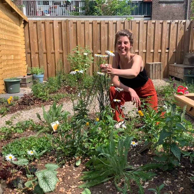 vrouw kijkt om hoekje wilde tuin